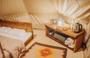 贝都古Alamu Eco Lodge的帐篷内带一张床和一张桌子的房间
