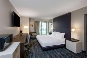 日内瓦41 Lakefront Hotel, Trademark Collection by Wyndham的配有一张床和一台平面电视的酒店客房