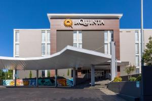 塔尔萨La Quinta Inn & Suites by Wyndham Tulsa Downtown - Route 66的前面有太阳记号的建筑