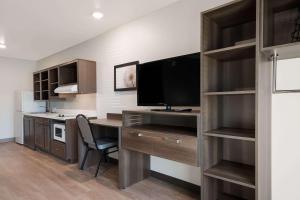 凤凰城WoodSpring Suites Phoenix-Deer Valley的客房设有带电脑和电视的书桌。