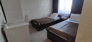 卡拉科尔Apartment in the Karakol heart的小房间设有两张床和一台冰箱