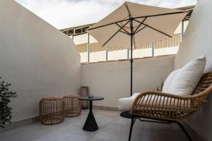 马拉加ICON Malabar的庭院配有桌椅和遮阳伞。