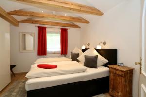 加尔米施-帕滕基兴Alpengold的一间卧室配有两张白色的红色窗帘