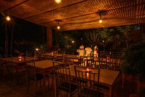 KanthalloorAnandavana Jungle Resort By Lexstays - Kanthalloor-Marayur的晚上,餐厅设有桌椅