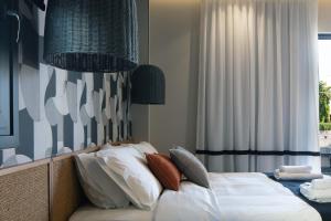 海若克利欧GD Gallery Suites的一间卧室配有带白色床单和枕头的床。