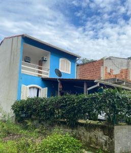 帕拉蒂Bela casa em condominio de frente a cachoeira的蓝色的房子,有窗户和砖砌建筑