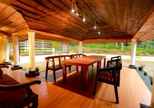 VaduvanchalChandragiri Wayanad Traditional Bungalow by VOYE HOMES的木制天花板下的一张木桌和椅子