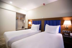 伊斯坦布尔Ramada Plaza Sultanahmet的配有白色床单的酒店客房内的两张床