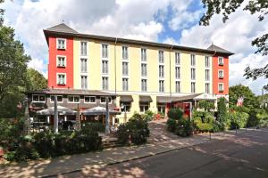 柏林Grünau Hotel的一座白色的大建筑,红色