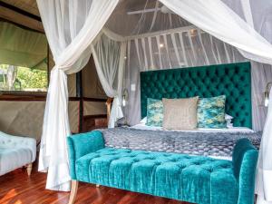 利文斯顿Tintswalo Siankaba的一间卧室配有一张绿松石床和天蓬。