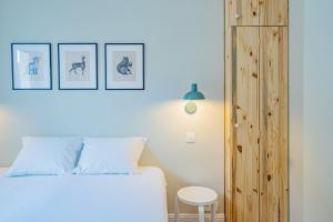 夏蒙尼-勃朗峰Majestic Alpin - A luxurious apartment with a nordic feel的卧室配有白色的床和木制橱柜。