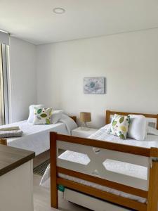 圣玛尔塔CONDOMINIO ZAZUE, SANTA MARTA, PLAYA BELLO HORIZONTE wifiiiii的一间卧室设有两张床和窗户。