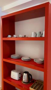 萨拉戈萨LC Apartamentos César Augusto的红色的架子,上面有盘子和茶壶
