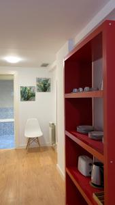 萨拉戈萨LC Apartamentos César Augusto的一间白色椅子的房间的红色书架