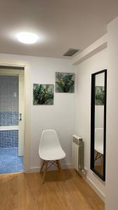 萨拉戈萨LC Apartamentos César Augusto的一间设有白色椅子和镜子的房间