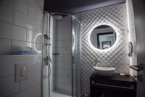 索普隆Hotel Palatinus的浴室配有盥洗盆和带镜子的淋浴