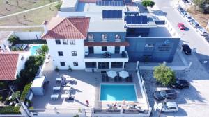 卡帕里卡海岸Villa Caparica Hostel的享有带游泳池的大楼的顶部景致