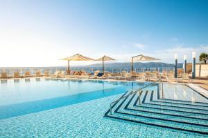 伊格拉恩TUI BLUE Makarska - Adults Only的一个带椅子和遮阳伞的大型游泳池