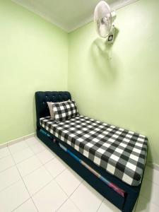 马日丹那Green Home Homestay Melaka的客房设有带风扇的黑白沙发。