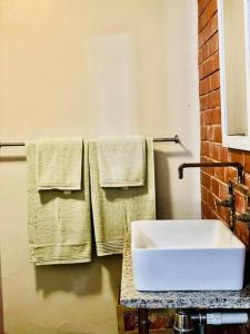 德班Ladybird的浴室配有白色水槽和毛巾