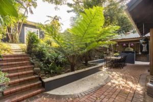 德班Ladybird的庭院设有楼梯、植物和桌子