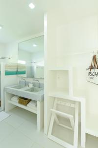 雅帕拉廷加Pe na Areia Boutique Hotel的白色的浴室设有水槽和镜子