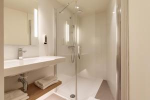 里尔B&B HOTEL Lille Lillenium Eurasanté的带淋浴和盥洗盆的白色浴室