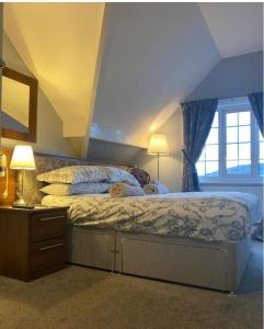 惠特比The Wayfarer, Robin Hoods Bay的一间卧室配有一张带蓝色窗帘的大床