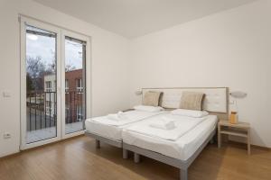 布拉格Prague City Residence的白色的卧室设有床和大窗户