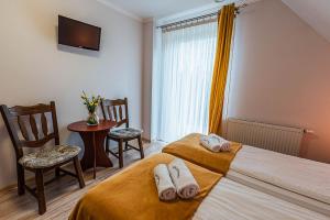 克鲁斯兹考采willapieninska的酒店客房带两张床和一张桌子以及椅子。