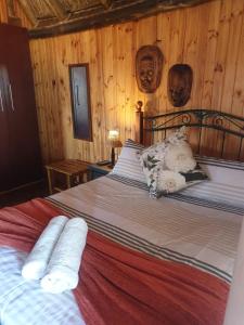 HondeklipbaaiHonne-Pondokkies的一间卧室配有一张带木墙的大床
