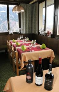 迪森蒂斯Hotel Péz Ault的桌子上摆放着两瓶葡萄酒的桌子