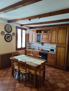 皮耶韦迪索利戈Casa Vacanze Monte Villa的厨房配有木桌、椅子和炉灶