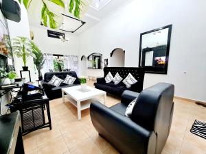 Kampong Alor GajahPrivate 4Bedroom Villa Pool,BBQ,Karaoke, Afamosa Resort的带沙发和桌子的客厅