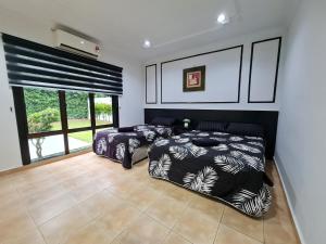 Kampong Alor GajahPrivate 4Bedroom Villa Pool,BBQ,Karaoke, Afamosa Resort的一间卧室设有两张床和大窗户