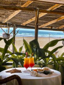 托弗海滩Casa na Praia Tofo- beach front hotel的一张桌子,上面放着两杯橙汁