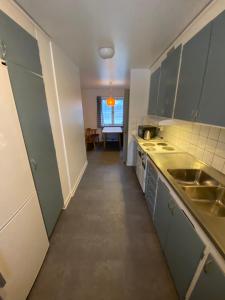 莫拉Bonäs bygdegård的厨房设有绿色橱柜和长长的走廊