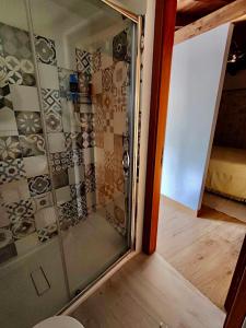 圣米歇尔迪甘泽Casa Vacanze La Cuntintizza的铺有木地板的玻璃淋浴间