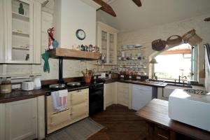 卡林福德Wood Quay - A truly unique, seafront experience!的厨房配有白色橱柜和黑炉灶烤箱。