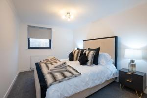 阿伯丁Panacotta House - Luxury 1 Bed Apartment in Aberdeen的一间卧室配有一张带黑白枕头的床