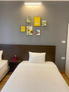 Phú ThọMộc Hương Hotel的卧室配有两张床,墙上挂有图片