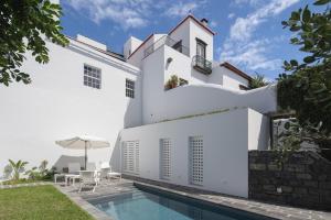 蓬塔德尔加达Solar de Santo André的白色的房子,设有游泳池和庭院