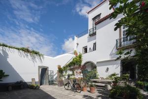 蓬塔德尔加达Solar de Santo André的一座白色的建筑,前面有一辆自行车停放