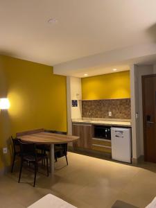 奥林匹亚Resort Solar das Águas的一间带桌子的厨房和一间带黄色墙壁的厨房