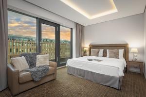 布拉格布拉格皇家酒店的卧室配有床、椅子和窗户。