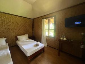 New AgutayaBabaland的一间卧室设有两张床、一台电视和一扇窗户。
