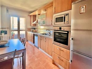 莱昂Housingleon- Casa Oliva con Garaje的厨房配有不锈钢用具和桌子