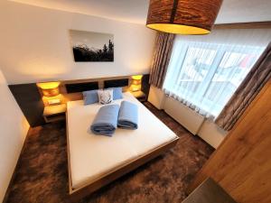 卡普尔Apart Garni Jägerheim的一间卧室配有白色的床和2个蓝色枕头
