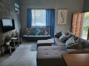 内尔斯普雷特Le Grix Guesthouse的带沙发和窗户的客厅