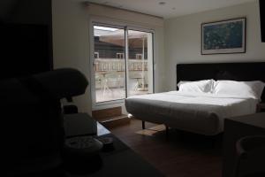 马德里Apartamentos Centro Jardines的一间卧室设有一张床,享有阳台的景色